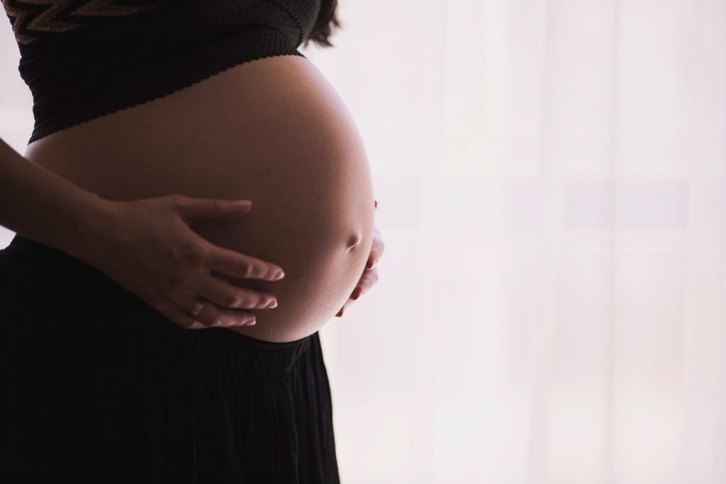Mujer embarazada con la barriga descubierta