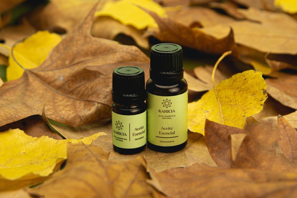 Dos aceites esenciales rodeados de ojas amarillas